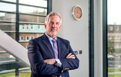 Picture of Rob Bristow inside the Manchester Cancer Research Centre.  Arms folded looking towards the camera. 