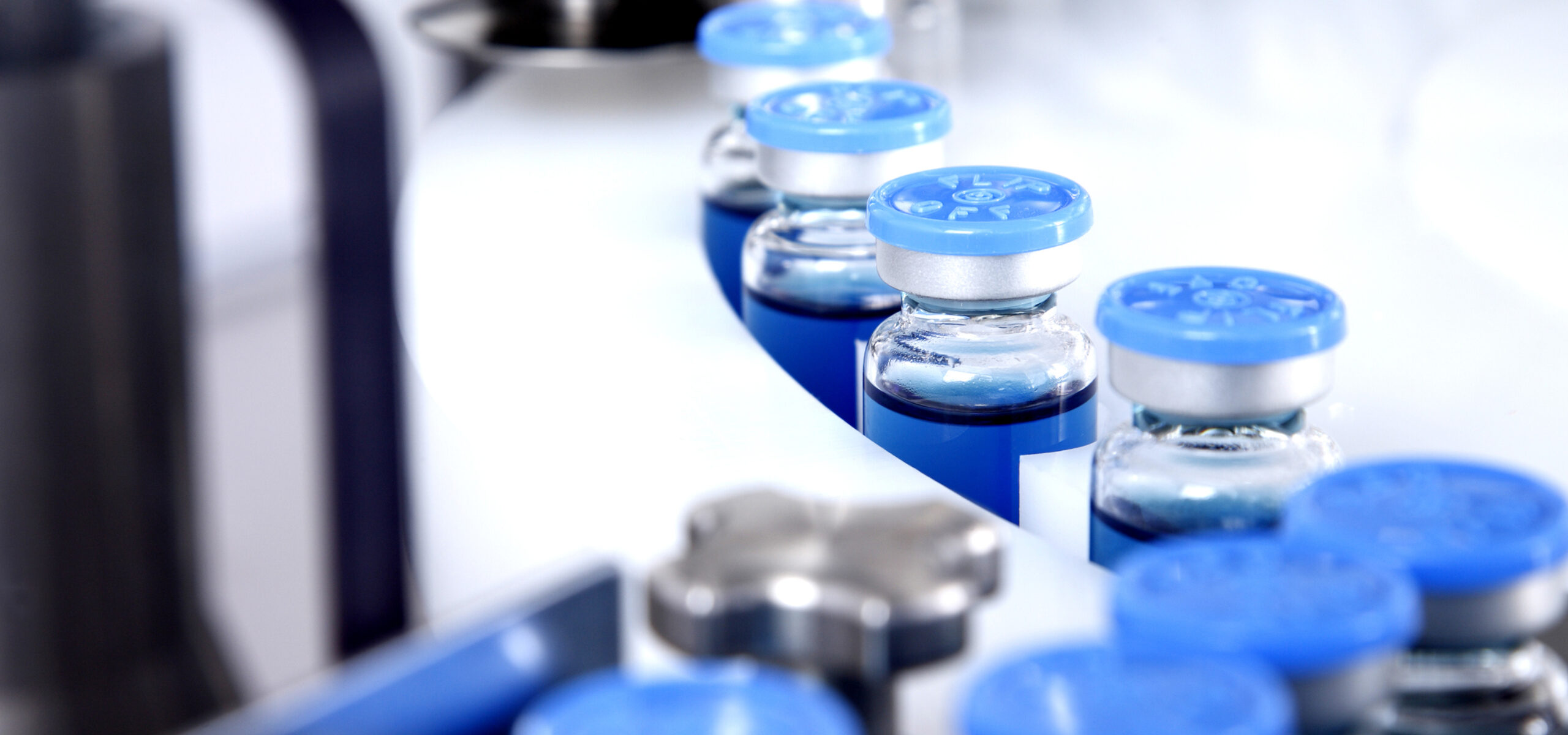 Glass bottles in production in the tray of an automatic liquid dispenser, a line for filling medicines against bacteria and viruses, antibiotics and vaccines