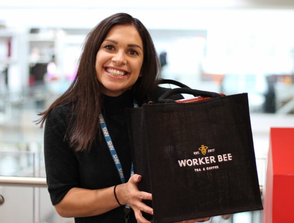 Rebecca Taylor holding Worker Bee cafe hamper prize