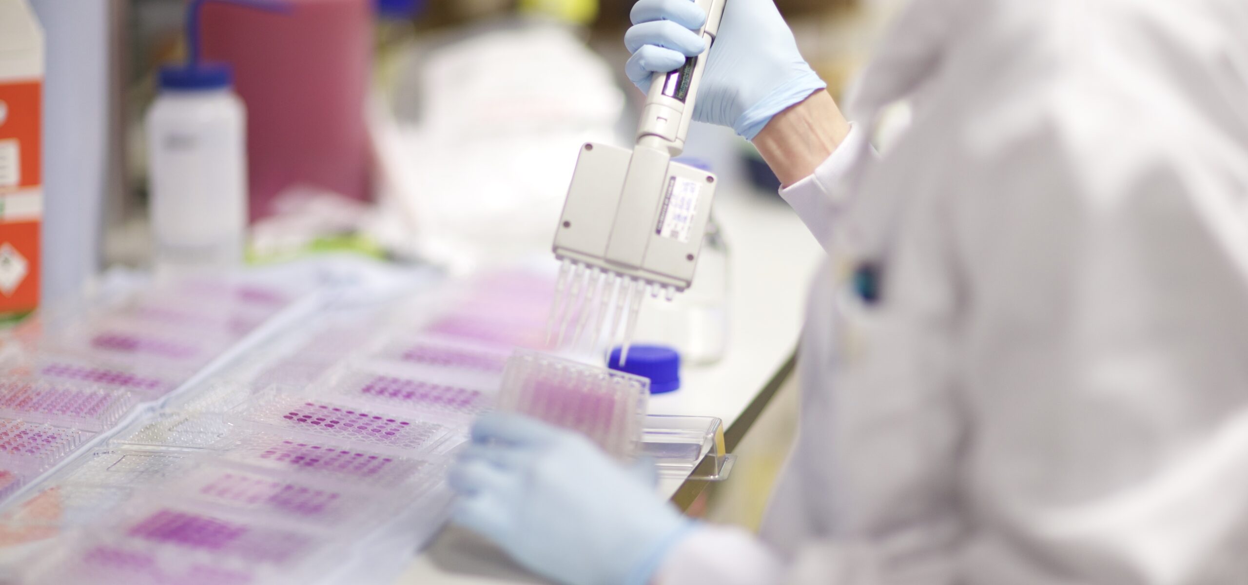 A scientist using a pipette in a laboratory