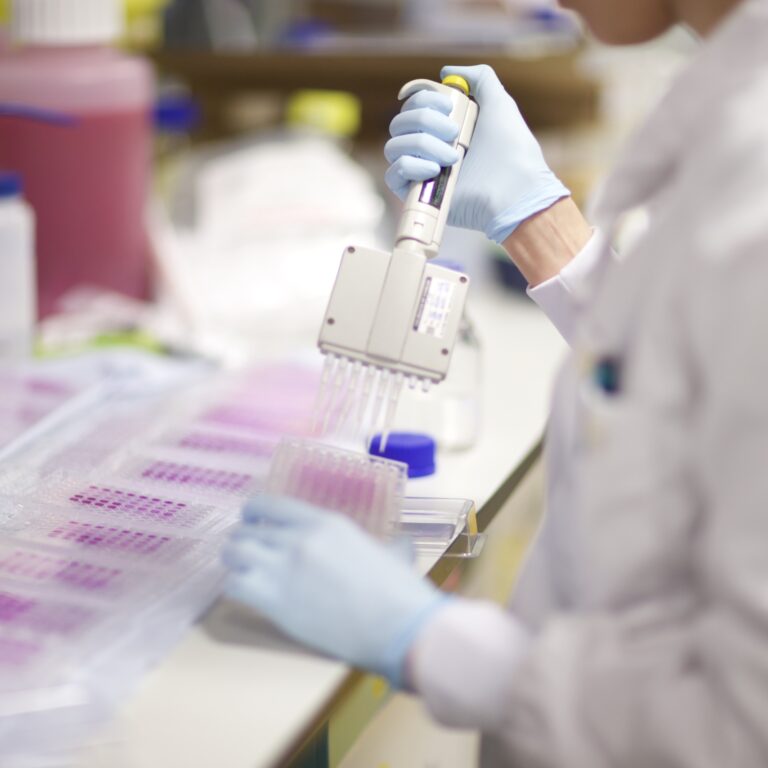 A scientist using a pipette in a laboratory